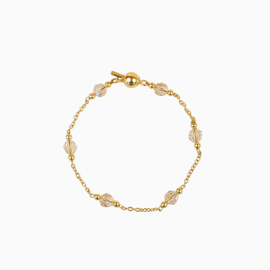 Bracelet Lafève en argent plaqué or avec perles de cristal champagne et fermoir boule sur fond clair
